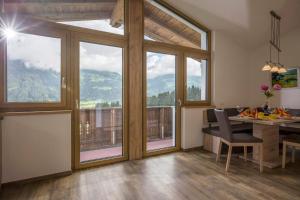 ein Esszimmer mit einem Tisch und einem Balkon in der Unterkunft Apart Andreas in Ried im Zillertal