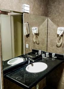 a bathroom with two sinks and a large mirror at Hotel Euro Suite São Paulo by Nacional Inn - A 600 METROS DA RUA 25 DE MARÇO in Sao Paulo