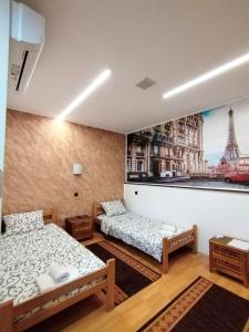 Pokój z 2 łóżkami i zdjęciem wieży Eiffel w obiekcie FUN ROOMS SOBE PRENOĆIŠTE w mieście Borča
