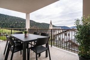 a table and chairs on a balcony with a view of a church at Apartment Klara in Meltina