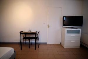 Cette chambre dispose d'une table, d'une télévision, d'une table et d'une chaise. dans l'établissement Canal Varignon, à Caen