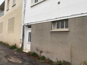 un bâtiment en briques avec une porte blanche à côté d'une rue dans l'établissement Canal Varignon, à Caen
