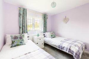 a bedroom with two beds and a window at *COTSWOLDS CORNER COTTAGE* Nr Stow-on-the-Wold in Lower Swell