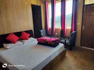 a bedroom with a bed with red pillows on it at Silver Dew Resorts and Restaurant in Dhanaulti +37 photos
