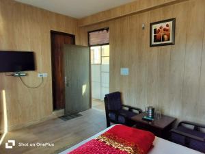 a room with a bed and a television and a table at Silver Dew Resorts and Restaurant in Dhanaulti
