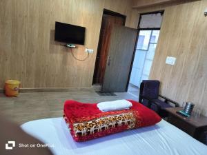 a hotel room with a red blanket on a bed at Silver Dew Resorts and Restaurant in Dhanaulti