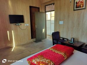 a bedroom with a bed with a red blanket on it at Silver Dew Resorts and Restaurant in Dhanaulti