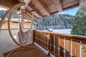 a hammock on the porch of a log cabin at Ferienhaus Larch Soge Apt Karin in Racines