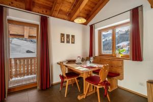a dining room with a table and chairs and windows at Ferienhaus Larch Soge Apt Karin in Racines