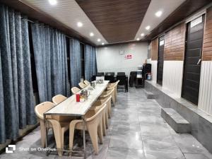 a restaurant with a long table and chairs at Silver Dew Resorts and Restaurant in Dhanaulti