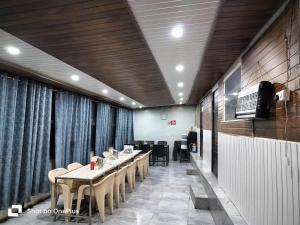 a dining room with tables and chairs and a television at Silver Dew Resorts and Restaurant in Dhanaulti
