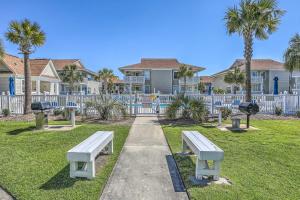 a park with two benches and palm trees at North Myrtle Beach Condo Community Pool and Hot Tub in Myrtle Beach