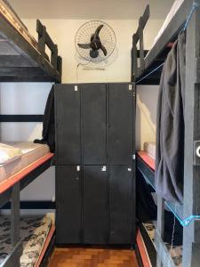 two black lockers in a room with a fan at Bella Ciao Hostel in Rio de Janeiro