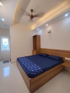 a bedroom with a bed with blue sheets and a ceiling at Shree Skanthas inn in Palni