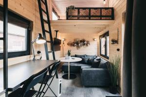 una sala de estar de una casa pequeña con mesa y sofá en Idyllisches Tiny House III mit Sauna, en Löbau