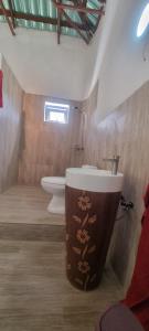 een badkamer met een wastafel en een toilet bij E House in Brufut