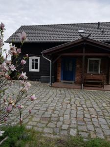 uma casa com uma porta azul e um pátio de tijolos em Ferienhaus Layla em Leipe