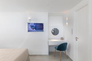 a bedroom with a bed and a chair and a sink at Aether Suite by Caldera Houses in Imerovigli