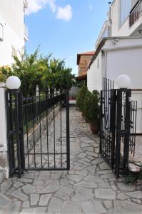a black iron fence with a stone walkway at Seaside Studios in Paralia Dionysiou