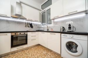 kuchnia z białymi szafkami, pralką i suszarką w obiekcie Madan Apartment - Chania city center w Chanii