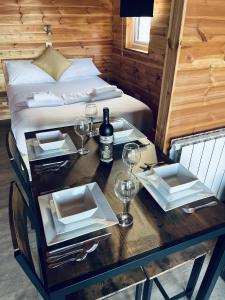 - une table avec des assiettes, des verres à vin et un lit dans l'établissement Lakeside Fishing Retreats, à Boston