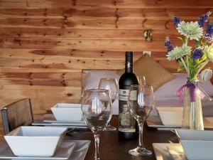 a table with a bottle of wine and wine glasses at Lakeside Fishing Retreats in Boston