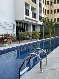 una piscina con bancos y un edificio en GRAY ONE - Apto novo, moderno, varanda, poucos passos da estação Luz, en São Paulo