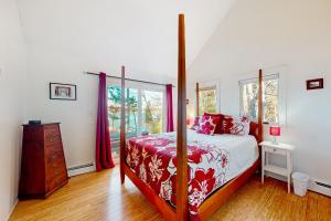 a bedroom with a bed with a red and white bedspread at Maine Waterfront Luxury Retreat 