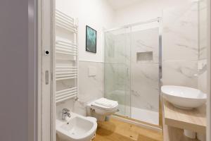 a white bathroom with a sink and a toilet at GuestHost - Cimiano M2 Balcony Apartment in Milan +13 photos
