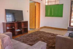 ein Wohnzimmer mit einem Flachbild-TV und einem Sofa in der Unterkunft Hermosa casa de 3 dormitorios in Encarnación