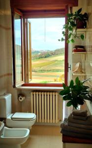 baño con aseo y ventana con vistas. en Appartamento LA VALLE Sala Monferrato, en Sala Monferrato