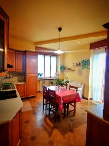 cocina con mesa y mantel rojo en Appartamento LA VALLE Sala Monferrato, en Sala Monferrato