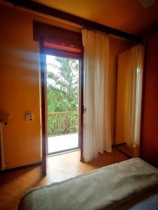 1 dormitorio con puerta corredera de cristal y ventana en Appartamento LA VALLE Sala Monferrato, en Sala Monferrato