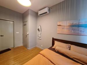 a bedroom with a bed and a painting on the wall at Luxury Tangerine Suites KLIA in Sepang