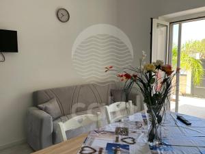 een eettafel met een vaas met bloemen erop bij Marks House - Spiaggia a 300m By Cala Salento in Porto Cesareo