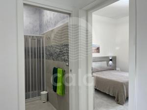 een slaapkamer met een bed en een glazen schuifdeur bij Marks House - Spiaggia a 300m By Cala Salento in Porto Cesareo