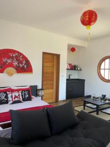 a living room with a bed and a couch at Mundarium - Chalés Temáticos com Hidromassagem e Cromoterapia in Santo Antônio do Pinhal