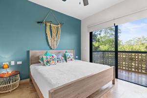 1 dormitorio con cama y pared azul en Luxurious Penthouse with Jungle View & Private Pool en Tulum