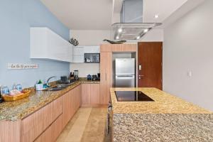 cocina con encimeras de granito y nevera en Luxurious Penthouse with Jungle View & Private Pool en Tulum