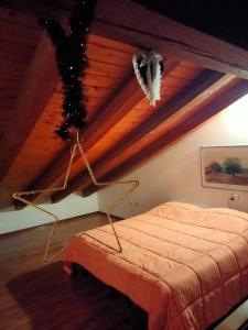 a bed in a room with a wooden ceiling at appartamento signorile con giardino in Aosta