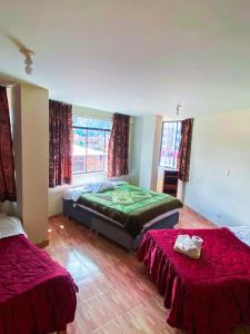 1 dormitorio con 2 camas con sábanas rojas en Chacraraju Hostel en Huaraz