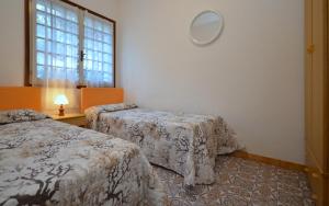 une chambre d'hôtel avec deux lits et une fenêtre dans l'établissement Villa Salvador, à Lignano Sabbiadoro