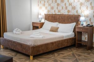 una camera da letto con un letto e asciugamani di Kairos Hotel a Pianura