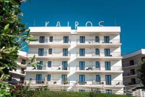 Un bâtiment blanc avec un panneau. dans l'établissement Kairos Hotel, à Pianura