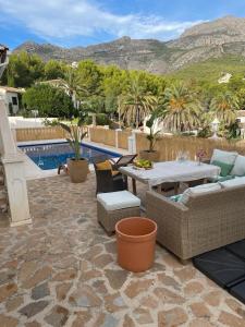 un patio con tavolo e sedie accanto alla piscina di Altea Bungalow 8p a Bernia