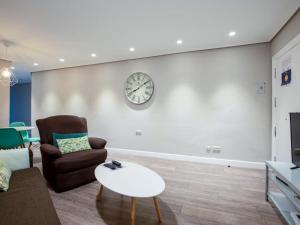 a living room with a couch and a clock on the wall at Bilbao San Mamés by Aston Rentals in Bilbao