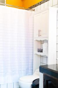 Hotel Villa del Lago في فلوريس: حمام مع ستارة دش بيضاء ومرحاض