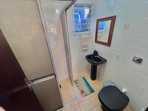 W łazience znajduje się prysznic, toaleta i umywalka. w obiekcie Bida's House Caiobá w mieście Matinhos