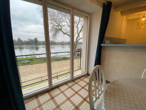 a room with a large window with a view of a river at Maison du pêcheur , située sur les bords de la Loire dans un lieu calme et paisible. in Rochefort-sur-Loire