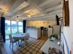a kitchen and living room with a table and a kitchen and a counter at Maison du pêcheur , située sur les bords de la Loire dans un lieu calme et paisible. in Rochefort-sur-Loire